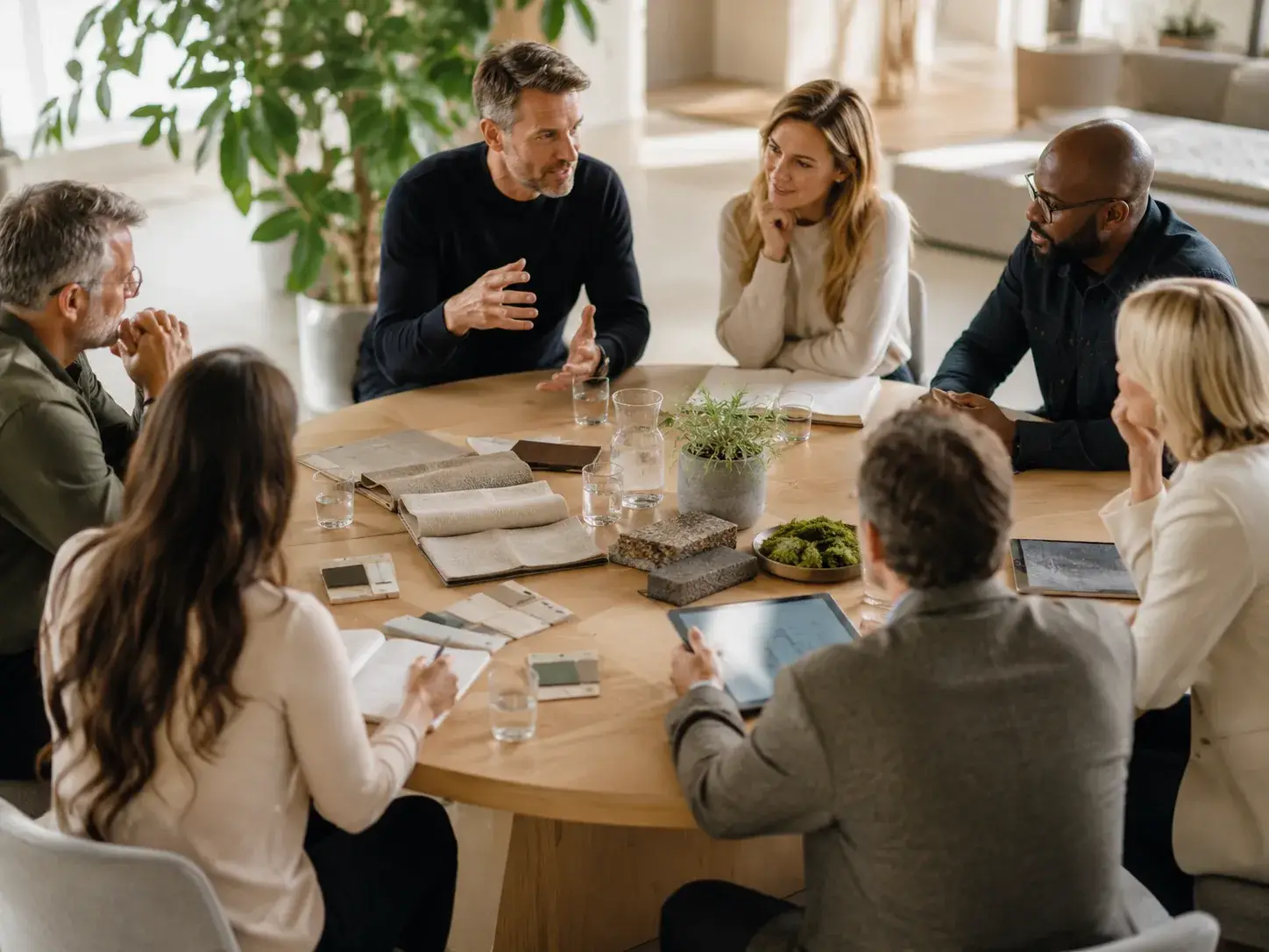 Groep professionals in overleg aan een ronde tafel over samenwerking en duurzame oplossingen